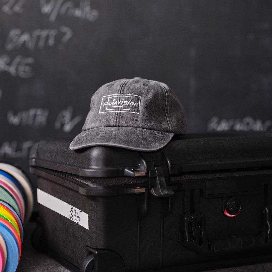 Dark Gray Panavision cap with a logo on top of a black suitcase against a dark background with text.